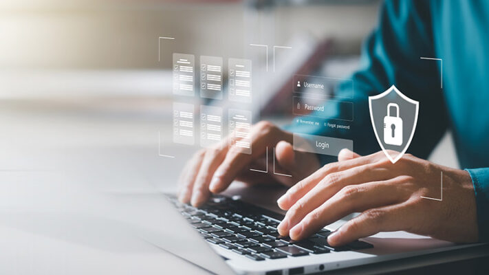 Person typing on laptop overlaid with digital security icons, including a shield and lock.