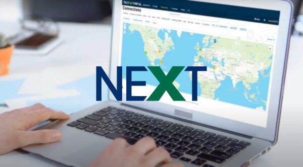 A person using a laptop displaying an interactive world map with the "NExT" logo overlaid on the screen.