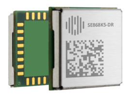 A microchip module with a printed QR code and the label "SE868K5-DR" on a metallic surface. The module has gold connectors on one side and a green circuit board on the other.