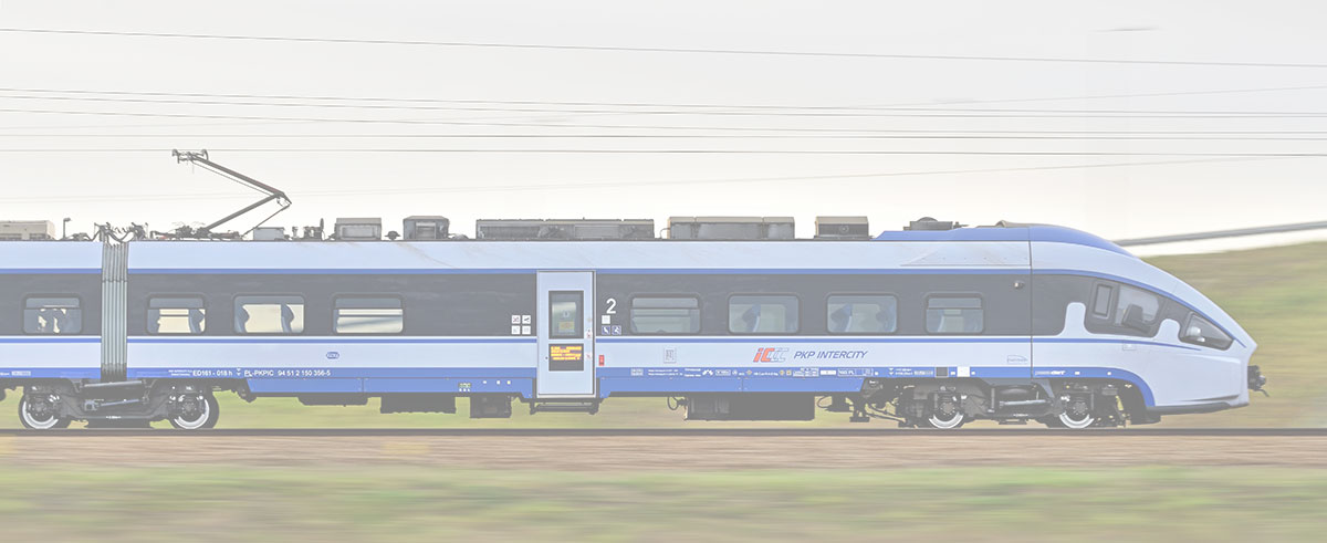 A blue and white modern passenger train travels along a track with a blurred background.