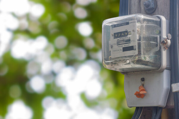 A smart electricity meter mounted outdoors on a pole with a blurred background.